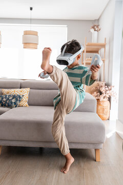 Hispanic boy playing VR game at home in bright living room