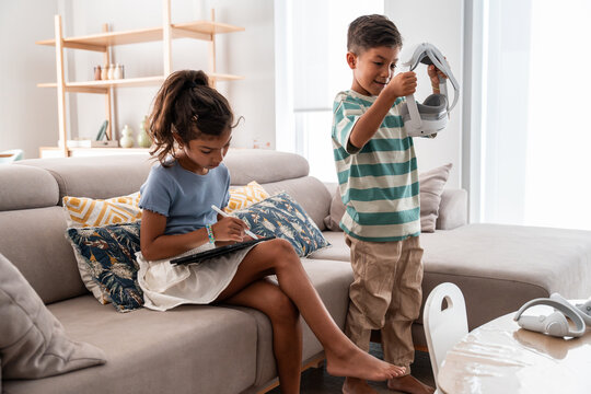 Hispanic family kids using virtual reality headset at home