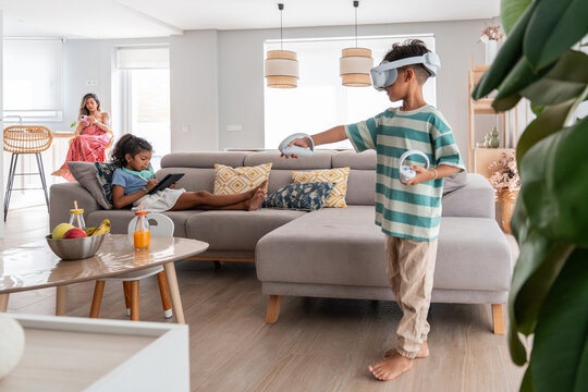 Hispanic family enjoying VR gaming and tablet time at home