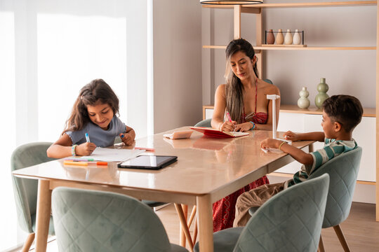 Hispanic family helping children study at home together