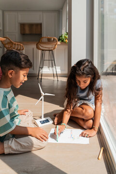 Hispanic siblings building a wind turbine science project