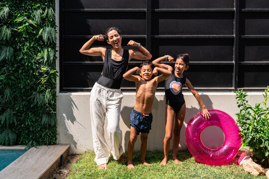Hispanic family posing outdoors by pool with inflatable ring
