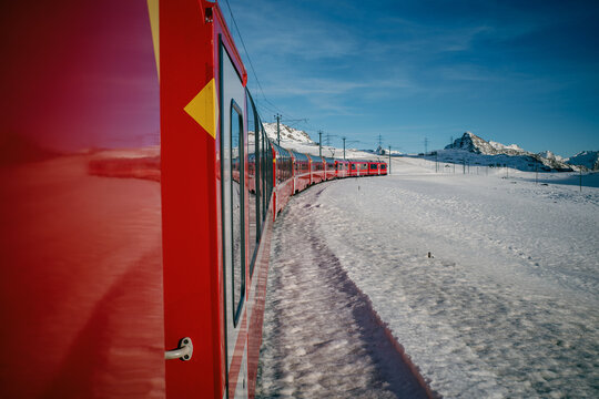 Scenic train winding through snowy alpine landscape
