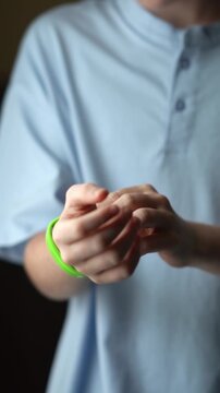 A teenager in a hotel room puts on an RFID or NFC bracelet. A boy puts on a contactless bracelet on his wrist. High quality FullHD footage