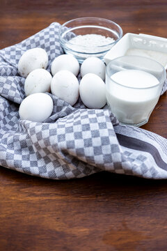 Fresh eggs and milk with flour on rustic table