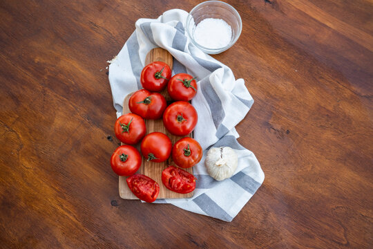 Fresh tomato still life with garlic, salt and kitchen towel