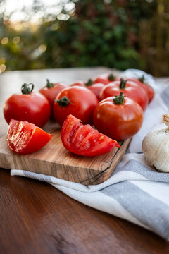 Fresh tomatoes on cutting board with garlic outdoors