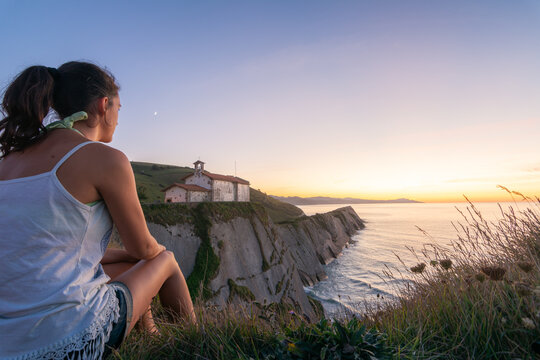 Woman watching sunset over sea from San Telmo cliff