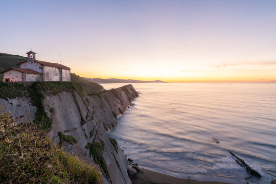 Sunset over Hermitage of San Telmo cliff and sea