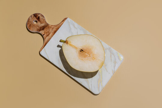Minimal still life of sliced pear on marble cutting board