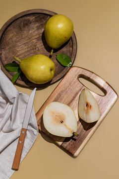 Fresh pear still life with wooden board, knife and napkin