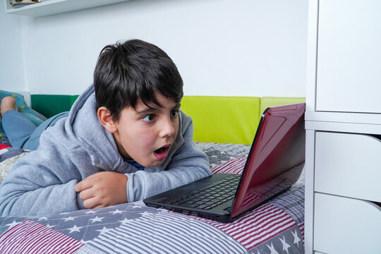 Teen boy surprised by stunning online content on laptop