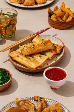 Appetizing spring rolls served with sauce and sides