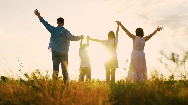 Parents children, raising their hands outdoors at sunset. Happy family. Group people standing hand in hand in nature park. Family prayer. Parents children united. Parents mom dad, child travel nature