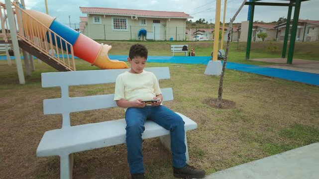 Young boy using a smartphone at the playground