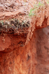 Fototapeta premium Excavation in red soil with ground cutting for foundation preparation at a construction site.