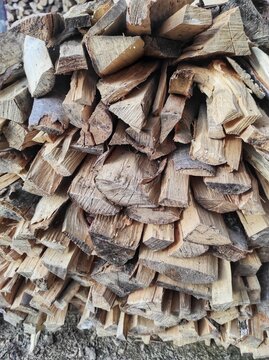 Close-up of stacked split firewood logs, natural wooden texture for background
