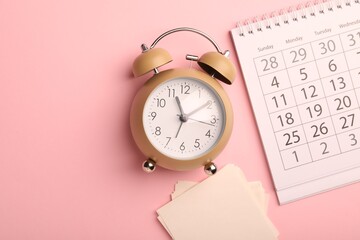 Naklejka premium Reminder. Alarm clock, sticky notes and calendar on pink background, flat lay. Space for text