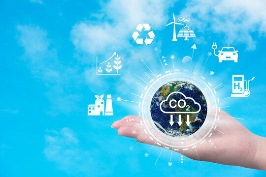 The world in your hand and CO2 reduced icon on blue sky background.Reduce global warming by reducing carbon emissions. concept.Element of this image furnished by NASA.