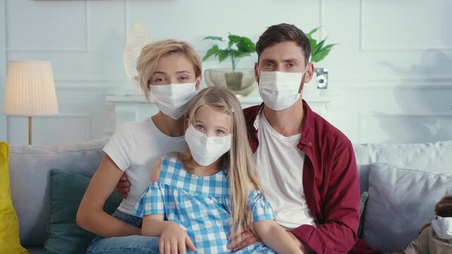 A family gathered at home, wearing masks together during the ongoing pandemic for safety