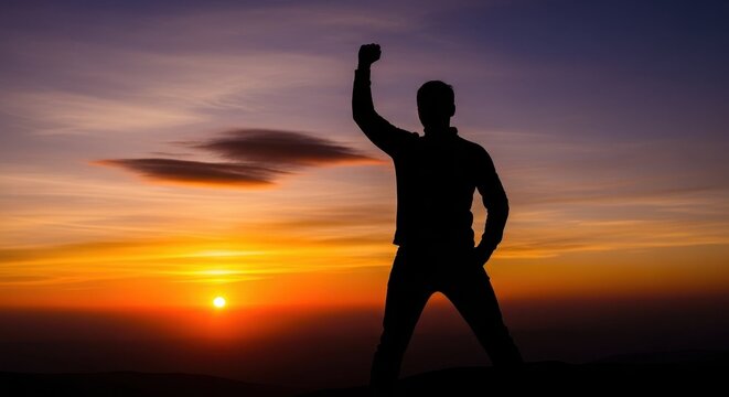 Silhouette of a person celebrating against a sunset background