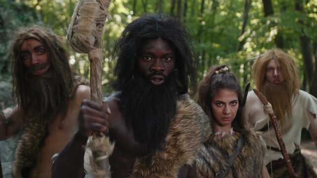 A vibrant Prehistoric Scene featuring Cavemen inhabiting a lush forest environment