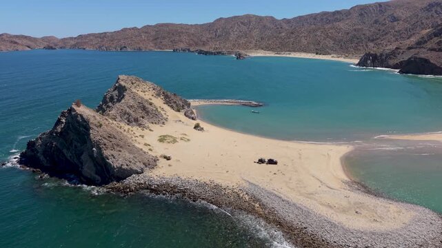 Aerial view shows an SUV with a teardrop camper trailer parked on the beach at Punta Final Bahia de Gonzaga in Baja California Mexico