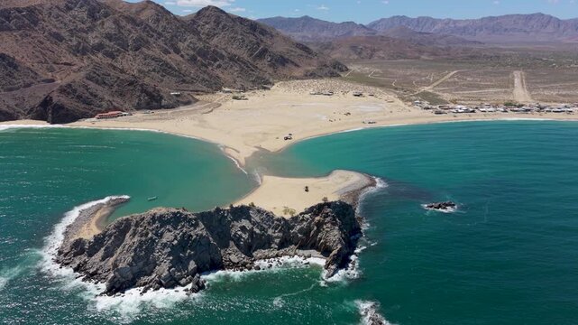 View the aerial perspective of an SUV with a teardrop camper on the beach at Punta Final, Bahia de Gonzaga in Baja California Mexico.