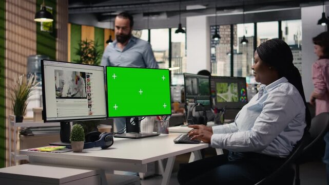 Isolated green screen next video streaming platform on dual monitors, digital software in modern office. Black man developing a marketing strategy to attract user engagement online.