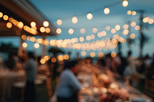 A blurred, atmospheric scene depicts a lively outdoor gathering illuminated by strings of warm fairy lights against a dusky blue sky.