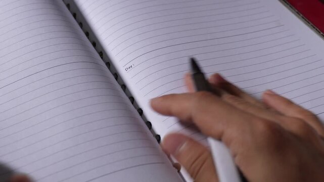 Hand with pen opening notebook