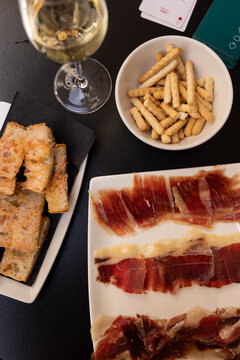 Traditional Spanish tapas - jamon iberico slices, breadsticks, pan con tomate, and cava