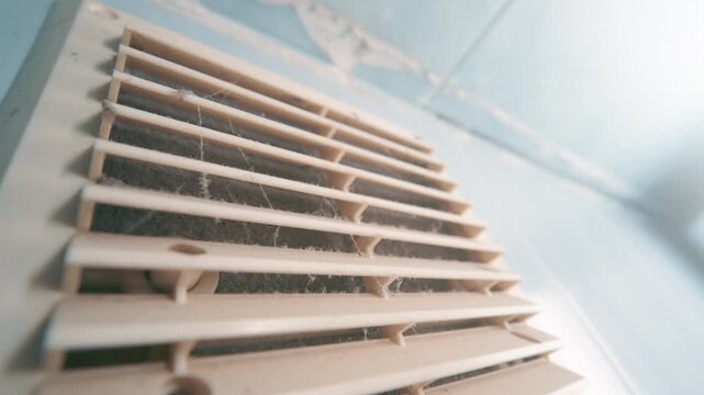 Dirty Clogged Ventilation Grille Covered with Dust and Cobwebs on Wall | Close-Up Wide Angle View of Neglected Air Vent | Home HVAC Problem