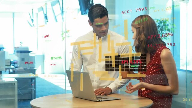 Vertical video: Woman typing at laptop man guiding woman showing finance charts overlay for review