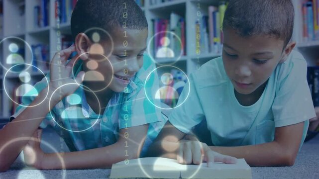Two boys lying in library, finger tracking text while initiating education UI appearing over book