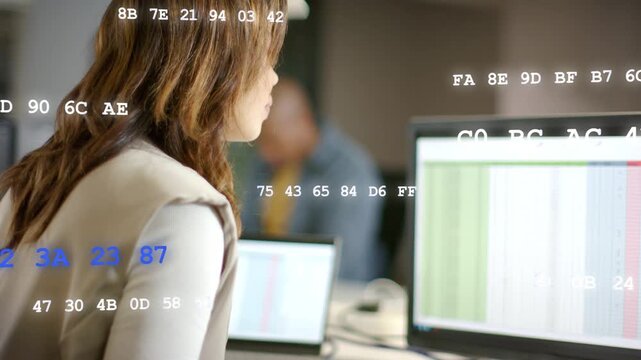 Woman tapping tablet reviewing tech data, causing hex codes shifting over screens while man smiling