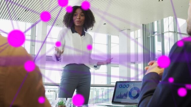 Woman leading meeting, pointing laptop charts and sparking purple overlay to show business impact