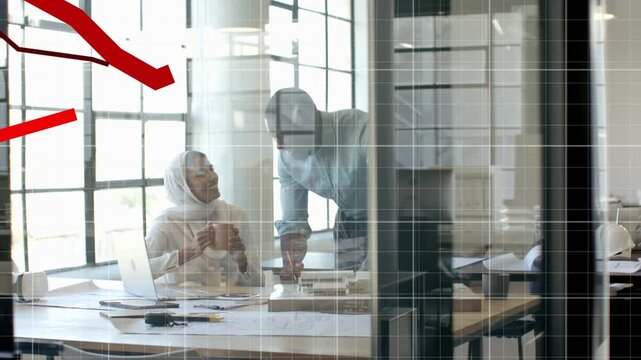 Colleagues leaning over desk pointing at plans, data causing red finance graph over docs for audit