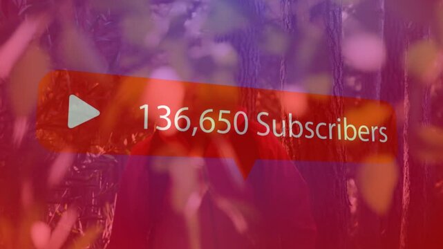 Man standing among trees, red subs graphic rising, revealing face, showing social media growth