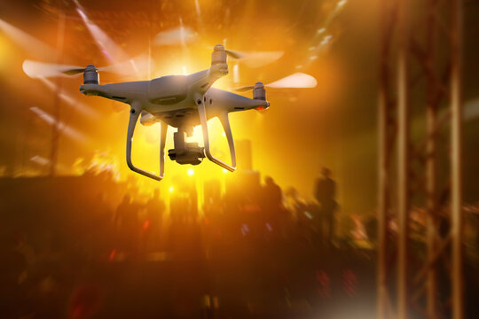 Drone flies over city crowd at sunset, performing aerial surveillance and urban monitoring.