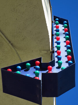 Retro Arrow Sign with Colorful Bulbs in Daylight