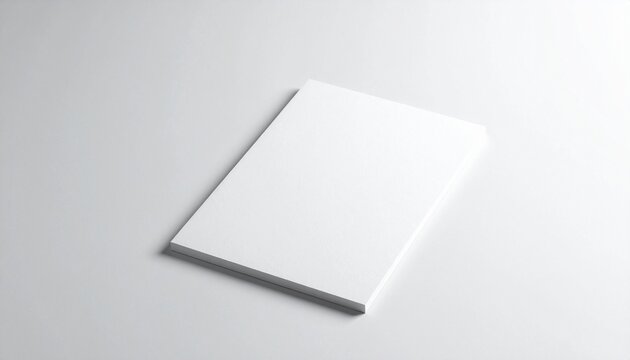A blank white notepad lying on a clean light surface indoors
