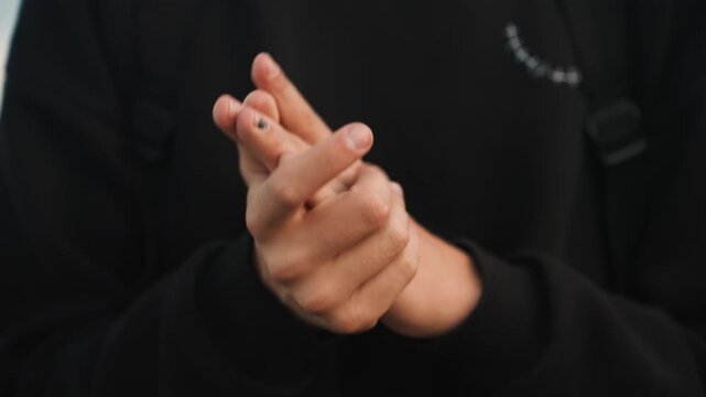 Dusk hands massaging sore fingers person caring for injured digits, gentle pressure on knuckles, hoodie sleeve visible, quiet roadside backdrop, healing selfcare mood and tactile closeup
