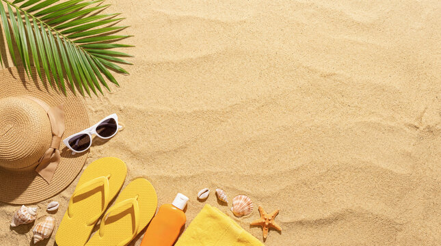Summer beach flat lay with hat, sunglasses, flip flops, sunscreen, towel and seashells on a sandy background