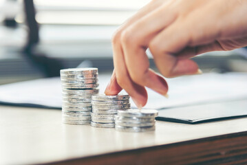 Fototapeta premium Hand holding stack coins using as business and financial concept