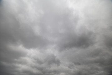 Fototapeta premium Overcast urban landscape. Gloomy city skyline with storm. Cloudfilled city view with dark storm approaching. Heavy gray clouds envelop skyline indicating impending storm