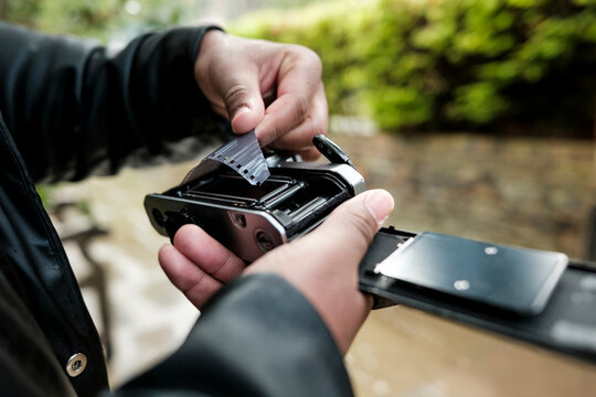 Person loading 35mm film into vintage analog camera