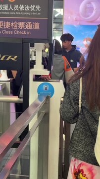 Suzhou, China, 01 April 2026 : Passengers queue at a high-speed rail ticket gate in a Chinese train station, scanning tickets at automated turnstiles in spring.