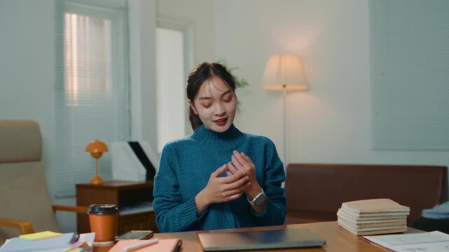 Young Asian woman happily finishing her work, closing the laptop with satisfaction. Freelancer feeling content after completing a task