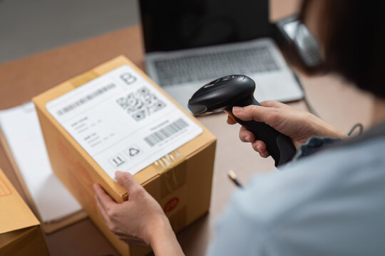 Worker scanning package barcode in office setting